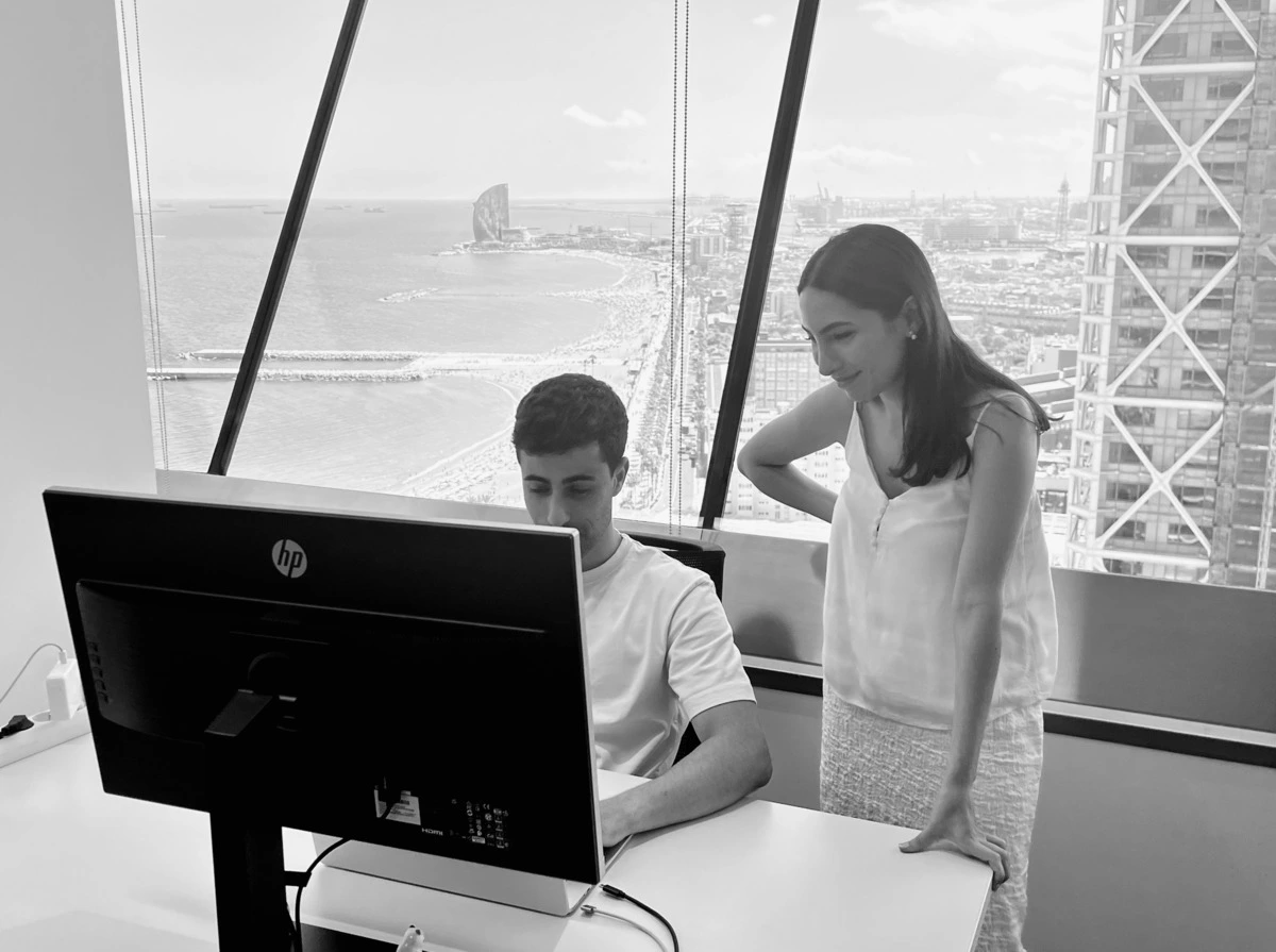 Dos personas trabajando desde las oficinas de Torre Mapfre